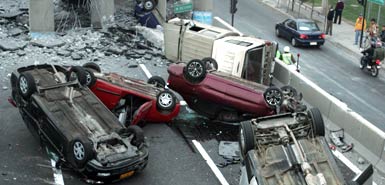Vehicles that were driving along a highway that collapsed near Santiago are seen overturned on the asphalt Saturday, Feb. 27, 2010 after a powerful earthquake struck central Chile early Saturday.