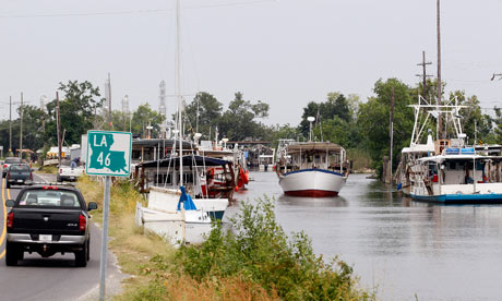 Oyster boat sails past anchored fishing boats in Yscloskey, Louisiana