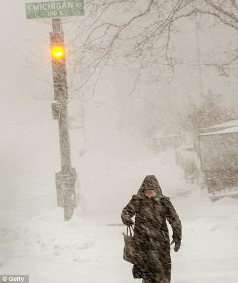 A woman crosses Michigan Avenue during a snowstorm February 2, 2011 in Chicago, Illinois