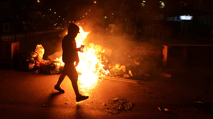 Supporters of Leopoldo Lopez, an ardent opponent of Venezuela's socialist government facing an arrest warrant after President Nicolas Maduro ordered his arrest on charges of homicide and inciting violence, light fires outside La Carlota military base, where he was taken after turning himself in, on February 18, 2014, in Caracas. (AFP Photo / Juan Barreto)