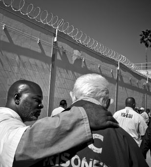 Secel Montgomery, left, who is serving a life sentence, takes care of an elder prisoner