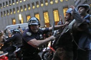 A New York City police officer shoves a  demonstrator affiliated with the Occupy Wall Street protests as they march through the streets in the Wall St. area, Friday, Oct. 14, 2011 in New York. (AP Photo/Mary Altaffer)