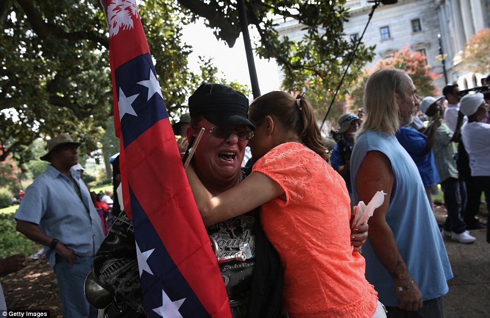 Protest: A woman clutching a Confederate flag during a KKK rally in South Carolina wails as emotions run high
