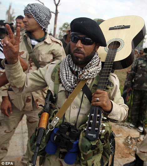 Libyan rebels flash victory signs during fighting in the city of Sirte
