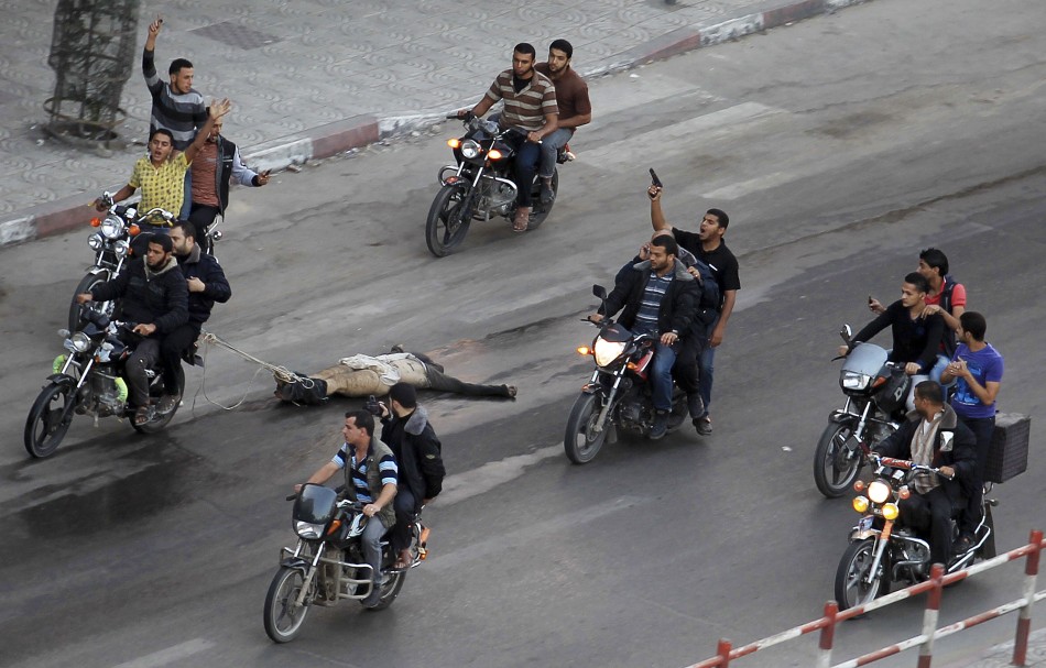 Palestinian gunmen ride motorcycles as they drag the body of a man, who was suspected of working for Israel, Palestinian gunmen ride motorcycles as they drag the body of a man, who was suspected of working for Israel (Reuters)