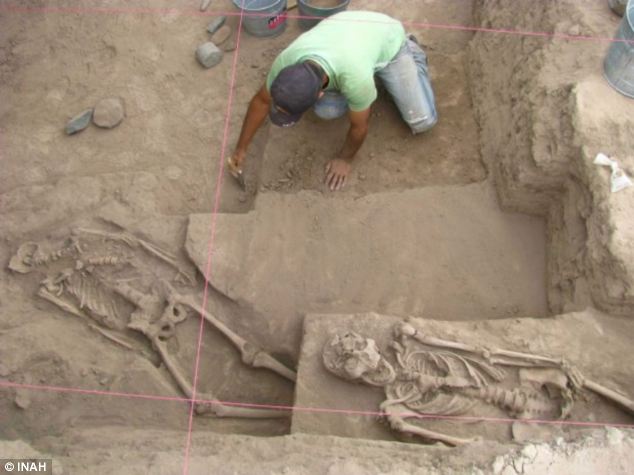 Experts at the site, where 25 bodies were discovered