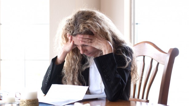 A woman receives a foreclosure notice. Photo: Shutterstock.com, all rights reserved.