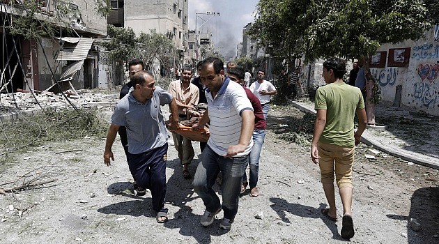 Run for LIves: Desperate Palestinians carry body from streets of Gaza’s Shejaia neighborhood after fierce shelling kills dozens of civilians.