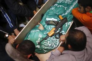 Gazans mourn next to the body of Hamas militant Mohammed al Hams during his funeral in Gaza City November 15, 2012.