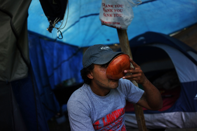 Rafael Santiago, who is homeless and works as a day laborer, takes a drink outside of the tent encampment where he lives in Waterbury, Connecticut. (Spencer Platt / Getty Images / AFP) 