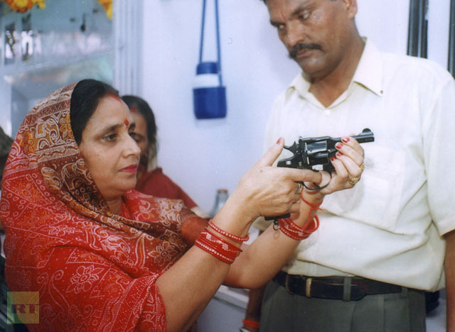 An Indian woman handles an Indian-made revolver at a newly opened gun shop in Lucknow.(AFP Photo / Pawan Kumar) 