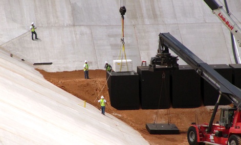 Commercial crews load the first of two containers with low-level radioactive waste from Los Alamos National Laboratory.