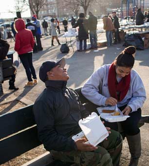 Rudy Cesar, left, and Maree Valdez eat a Thanksgiving meal on a bench after volunteering with Hurricane Sandy cleanup in the Rockaways neighborhood of the Queens borough of New York, November 22, 2012. (Photo: Michael Nagle / The New York Times) 